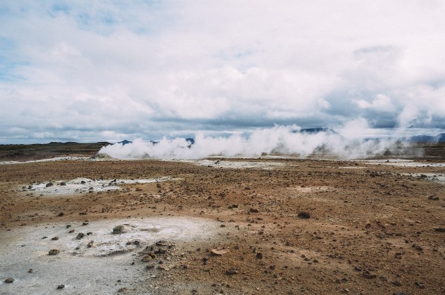 A photo of the earth - mud, ground, dried plants, and a cloudy sky