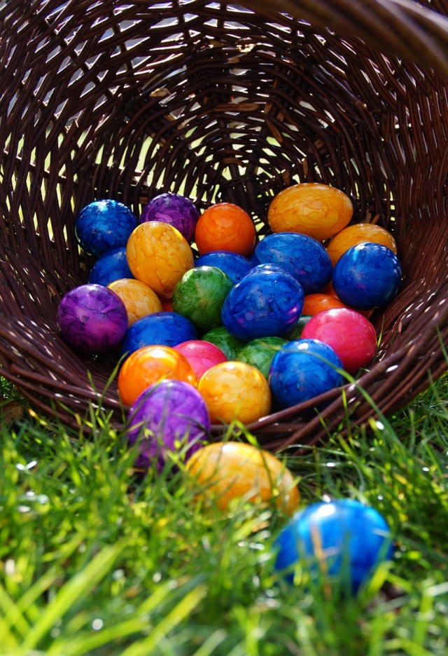 Colorful eggs in a basket on the grass photo