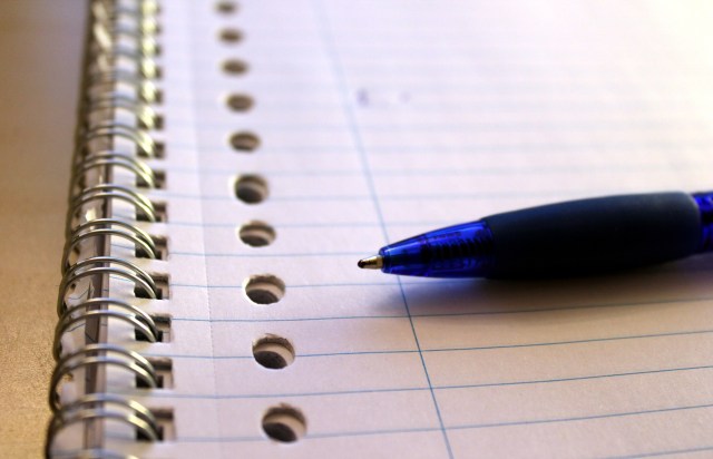 Photo of a spiral notebook and a pen ready to be used for writing