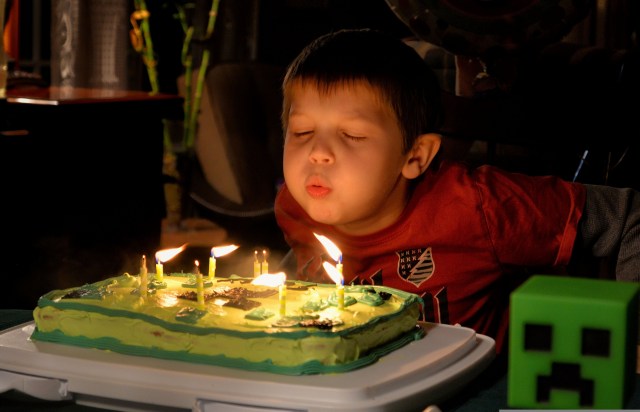 Image of a child blowing out candles on a birthday cake